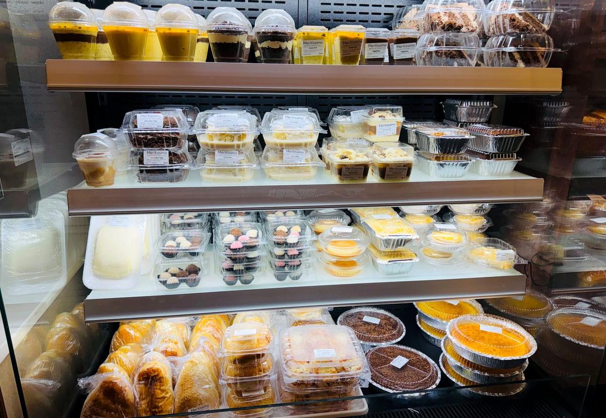 Vitrine de doces brasileiros — pudim, brigadeiro e tortas na padaria Meritíssimo, Fitchburg MA