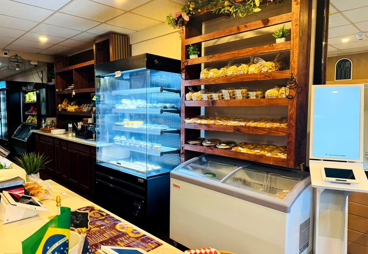 Balcão da padaria do Meritíssimo com prateleiras de pães, bolos e doces