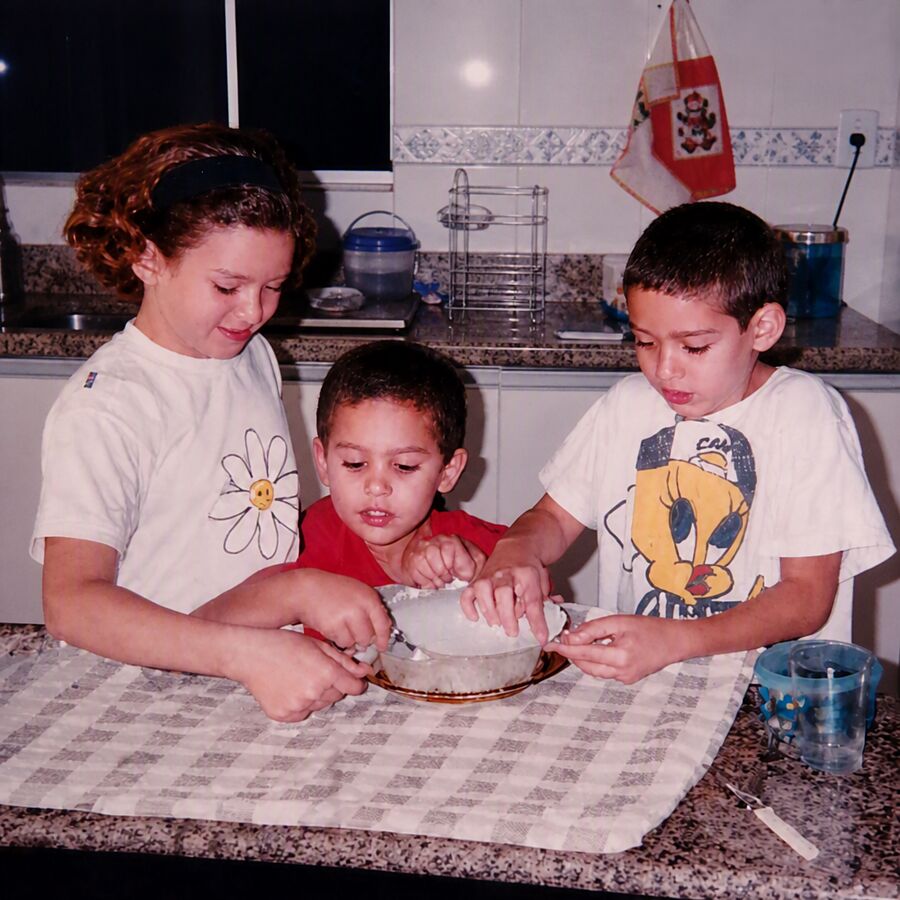 Ana, André e Daniel crianças, trabalhando a massa juntos na cozinha de casa