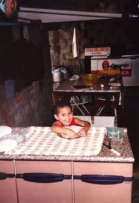 Daniel sorrindo com as mãos na massa, na mesma bancada