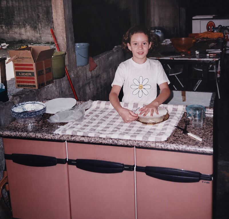 Ana, a filha mais velha, preparando massa na bancada da cozinha de casa