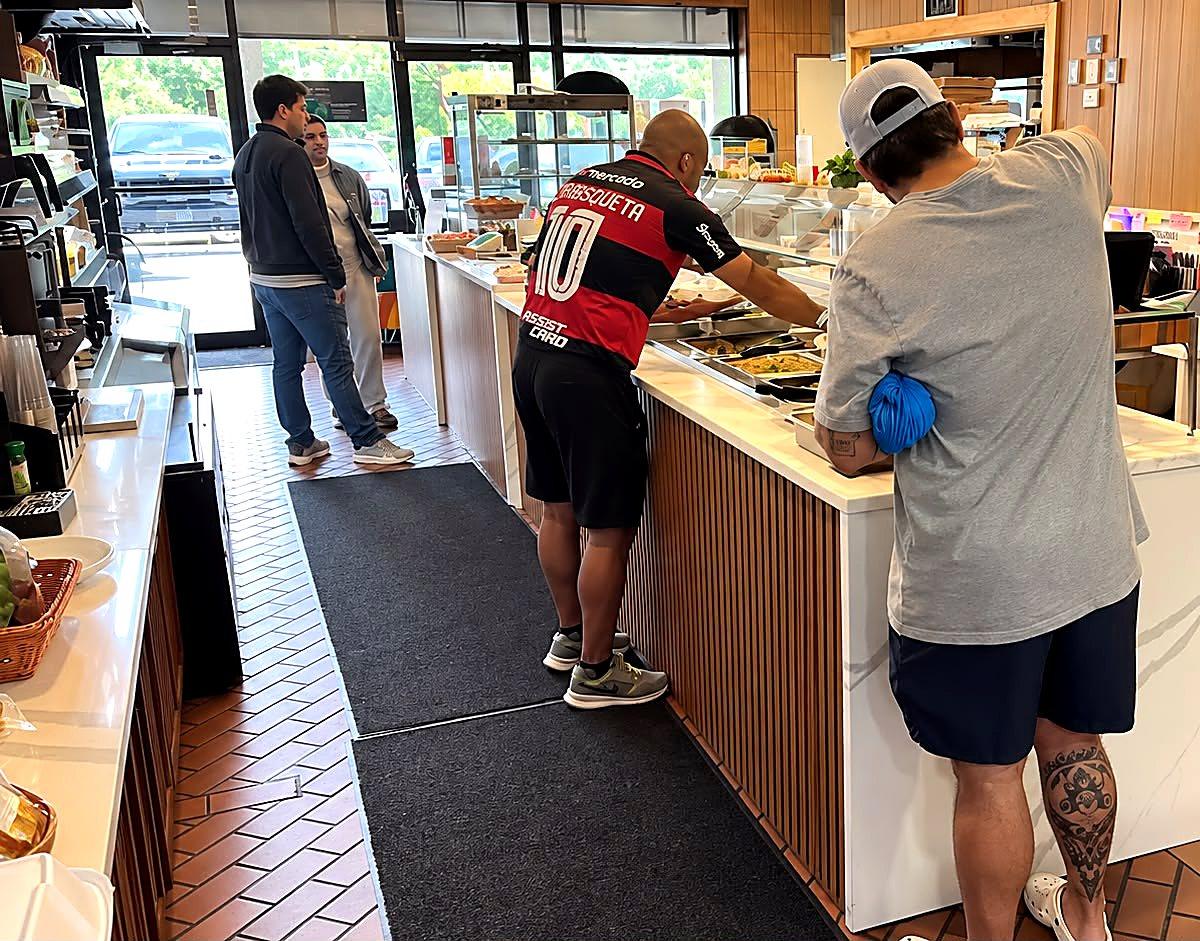 Clientes no balcão do Meritíssimo, restaurante brasileiro em Fitchburg MA